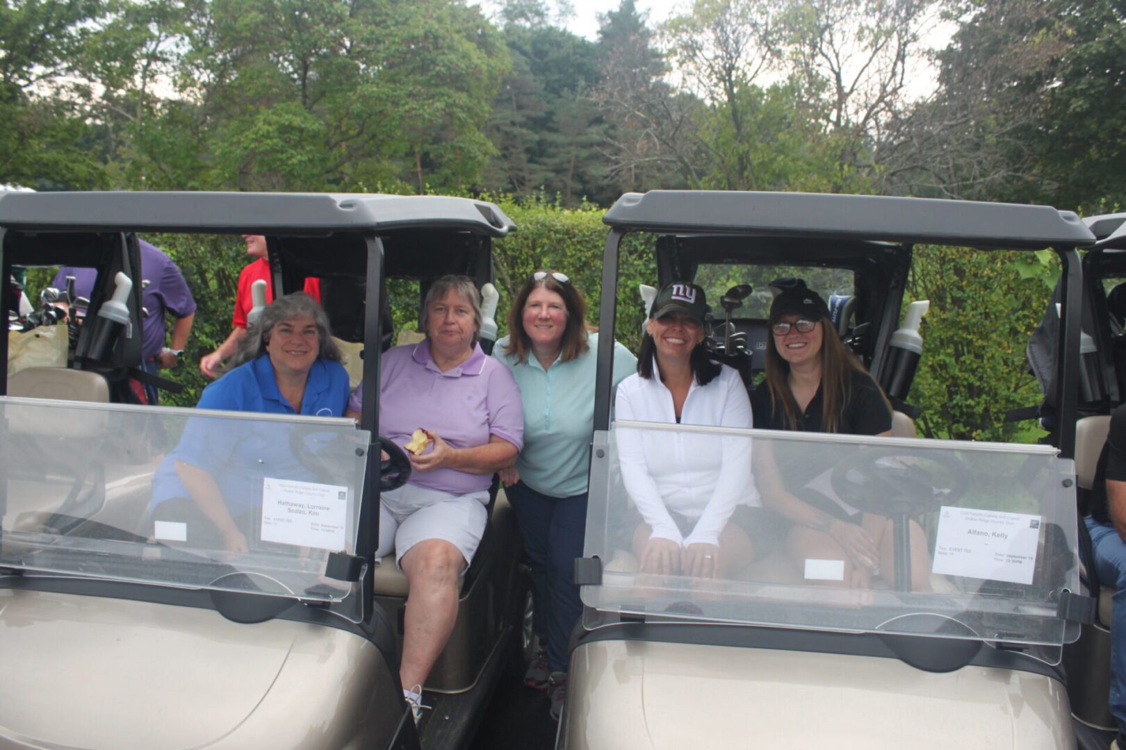 A group of people posing for a picture in a golf cart.