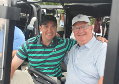 Two men sitting in a golf cart.