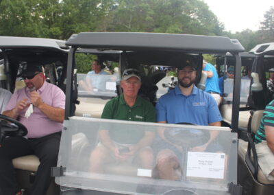 A group of people sitting in a golf cart.