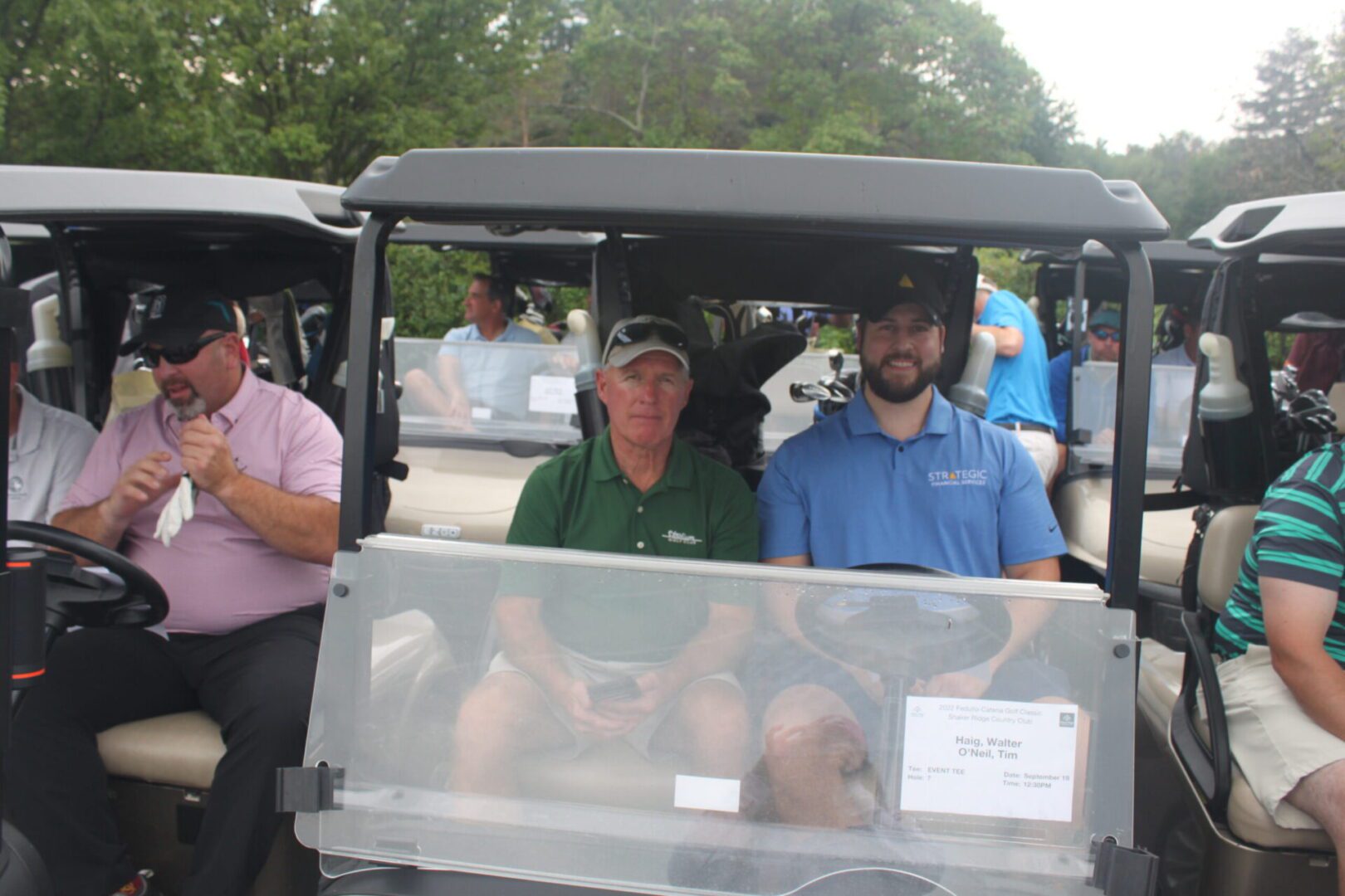 A group of people sitting in a golf cart.