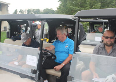 A group of men sitting in golf carts.