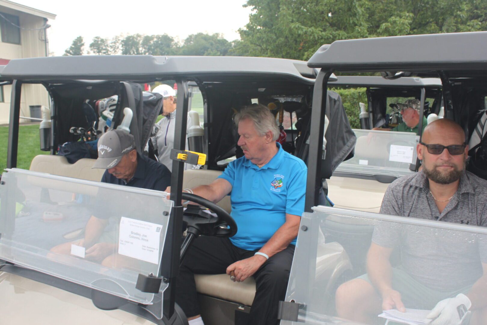 A group of men sitting in golf carts.