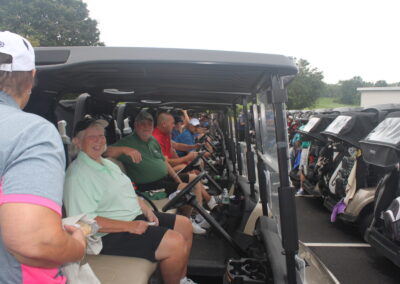 A group of people sitting in a golf cart.