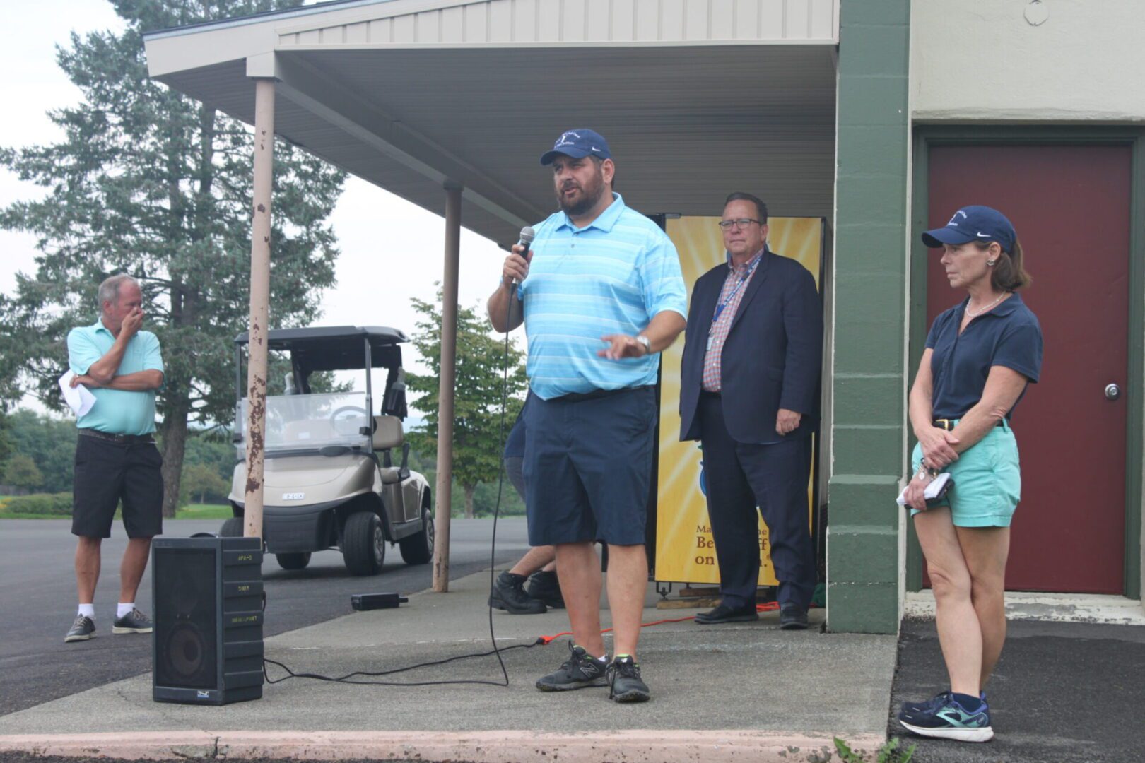 A group of people standing in front of a building with a microphone.