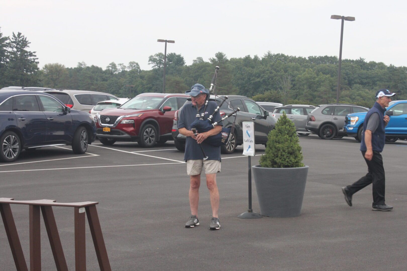 A man is standing in a parking lot.