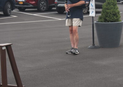 A man playing a bagpipe in a parking lot.