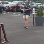A man playing a bagpipe in a parking lot.