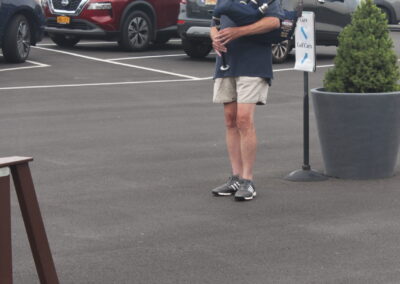 A man playing a bagpipe in a parking lot.