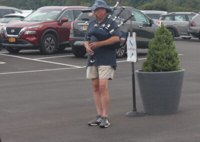 A man playing a bagpipe in a parking lot.