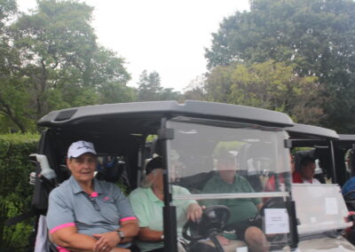 A group of people sitting in a golf cart.