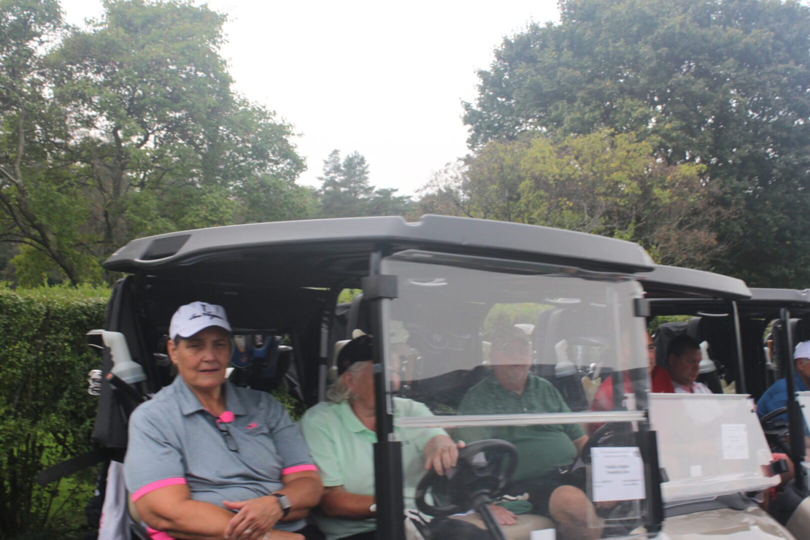 A group of people sitting in a golf cart.