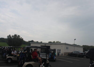 A group of golf carts parked in a parking lot.