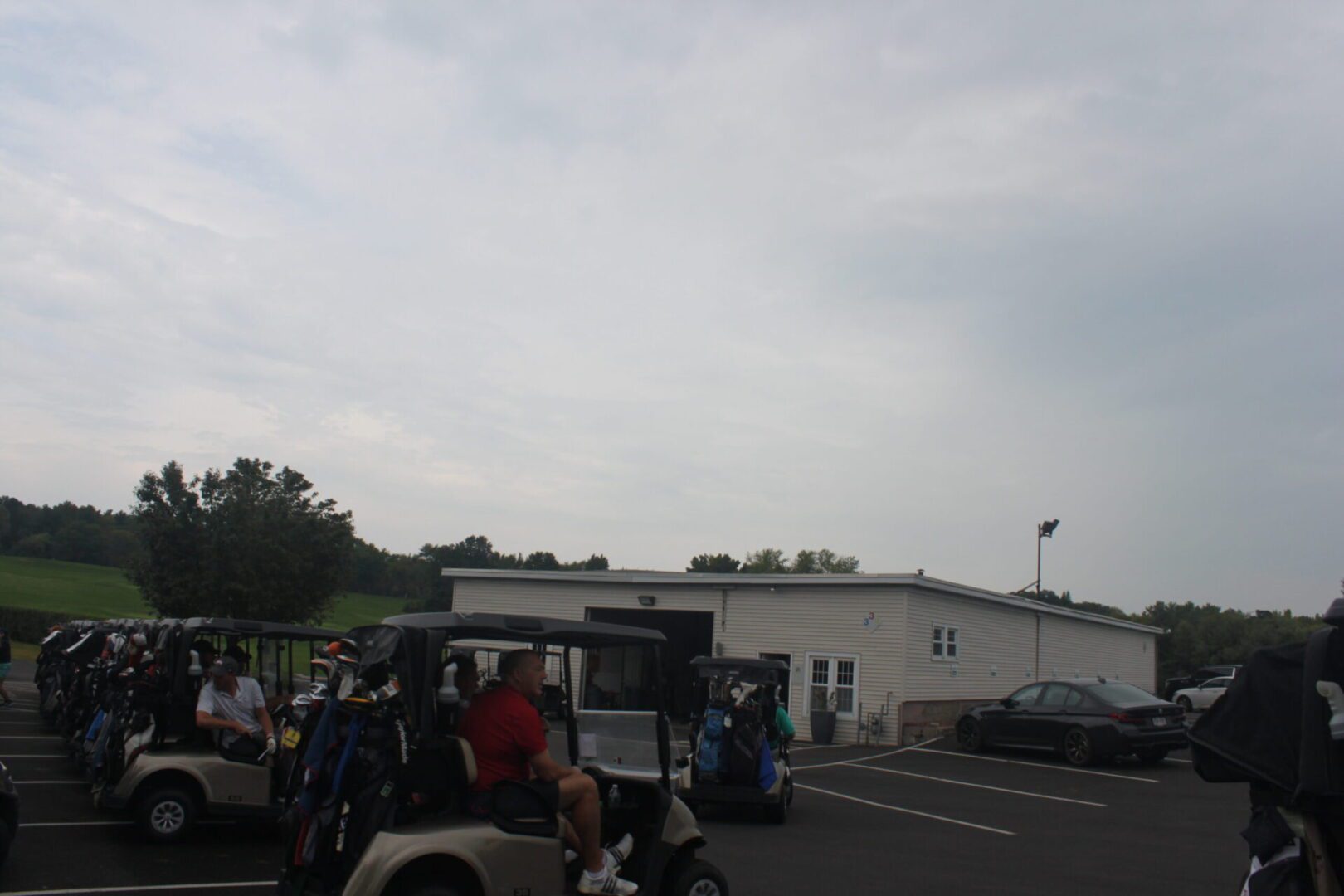 A group of golf carts parked in a parking lot.