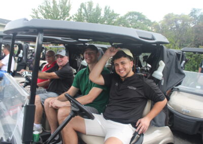 A group of men sitting in a golf cart.