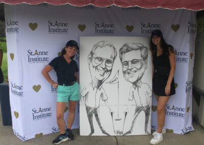 Two women standing next to a caricature of a man and a woman.