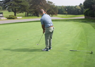 A man putting on a green golf course.