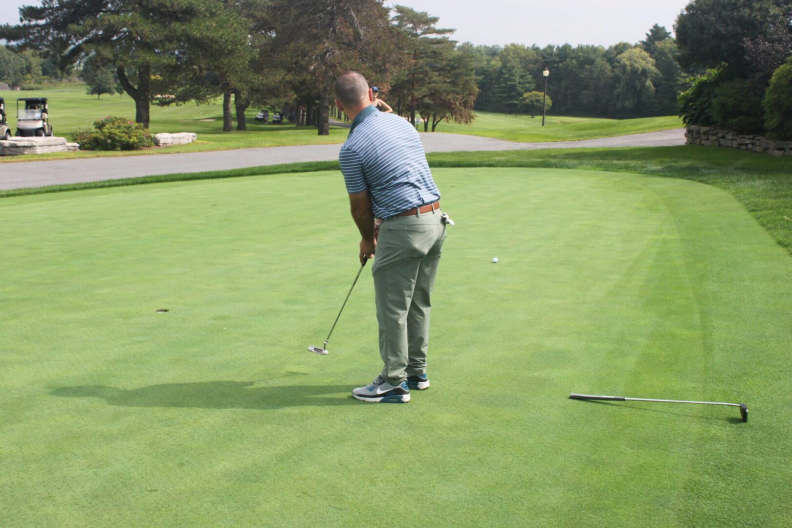 A man putting on a green golf course.