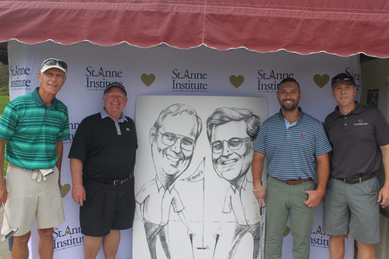 A group of men posing for a photo in front of a caricature.