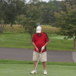 A man is preparing to hit a golf ball.