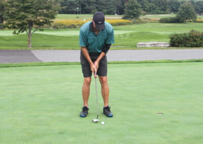 A man putting a golf ball on a green.