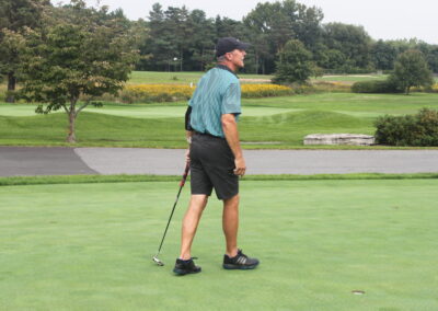 A man is standing on a golf course.