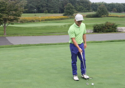 A man is putting a golf ball on a green.