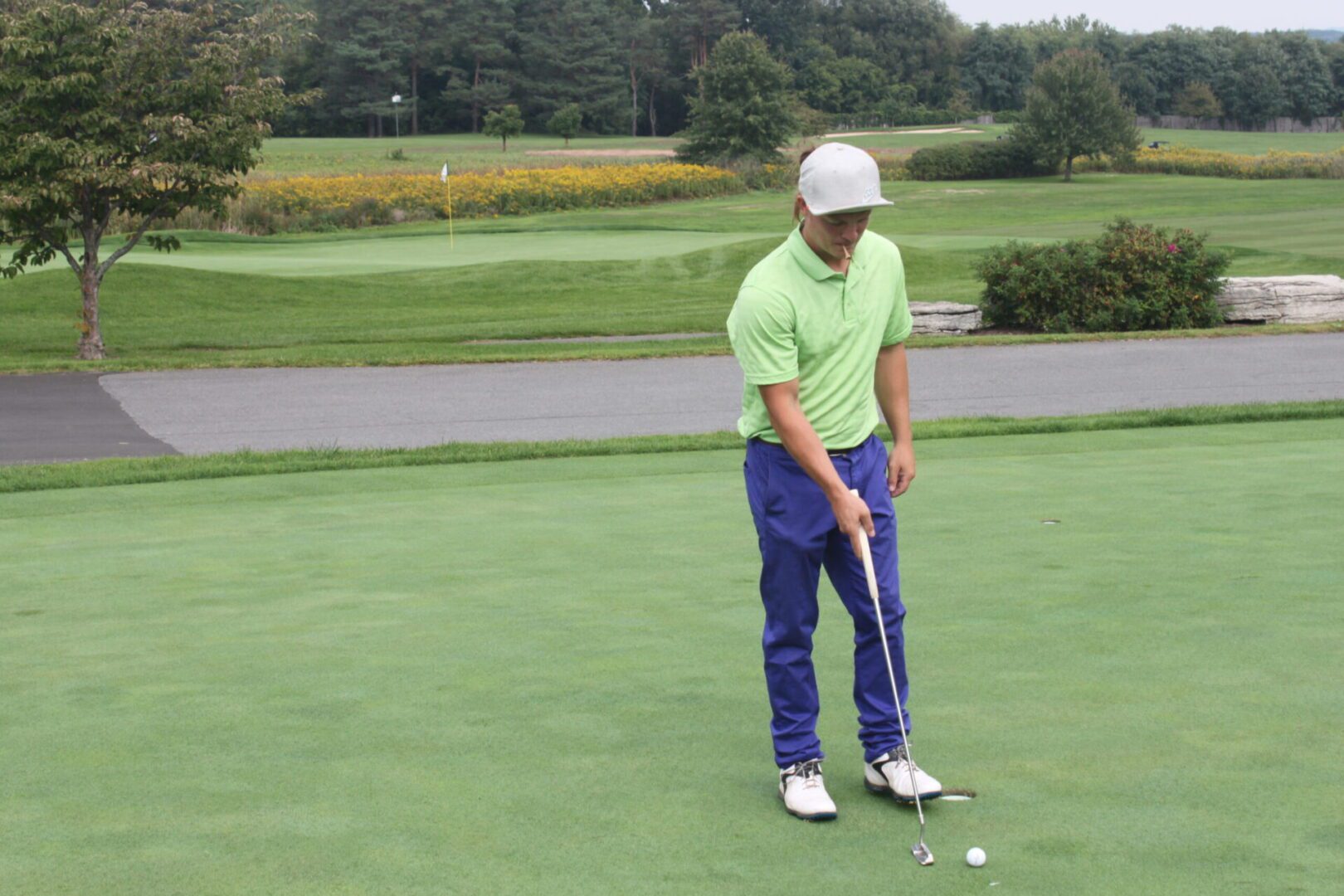 A man is putting a golf ball on a green.