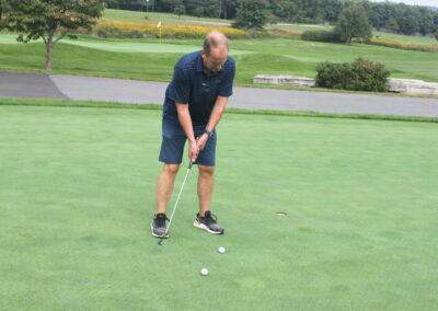 A man is putting a ball on a golf course.