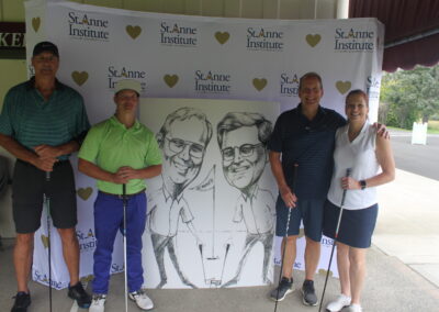 A group of people posing for a photo with a caricature.