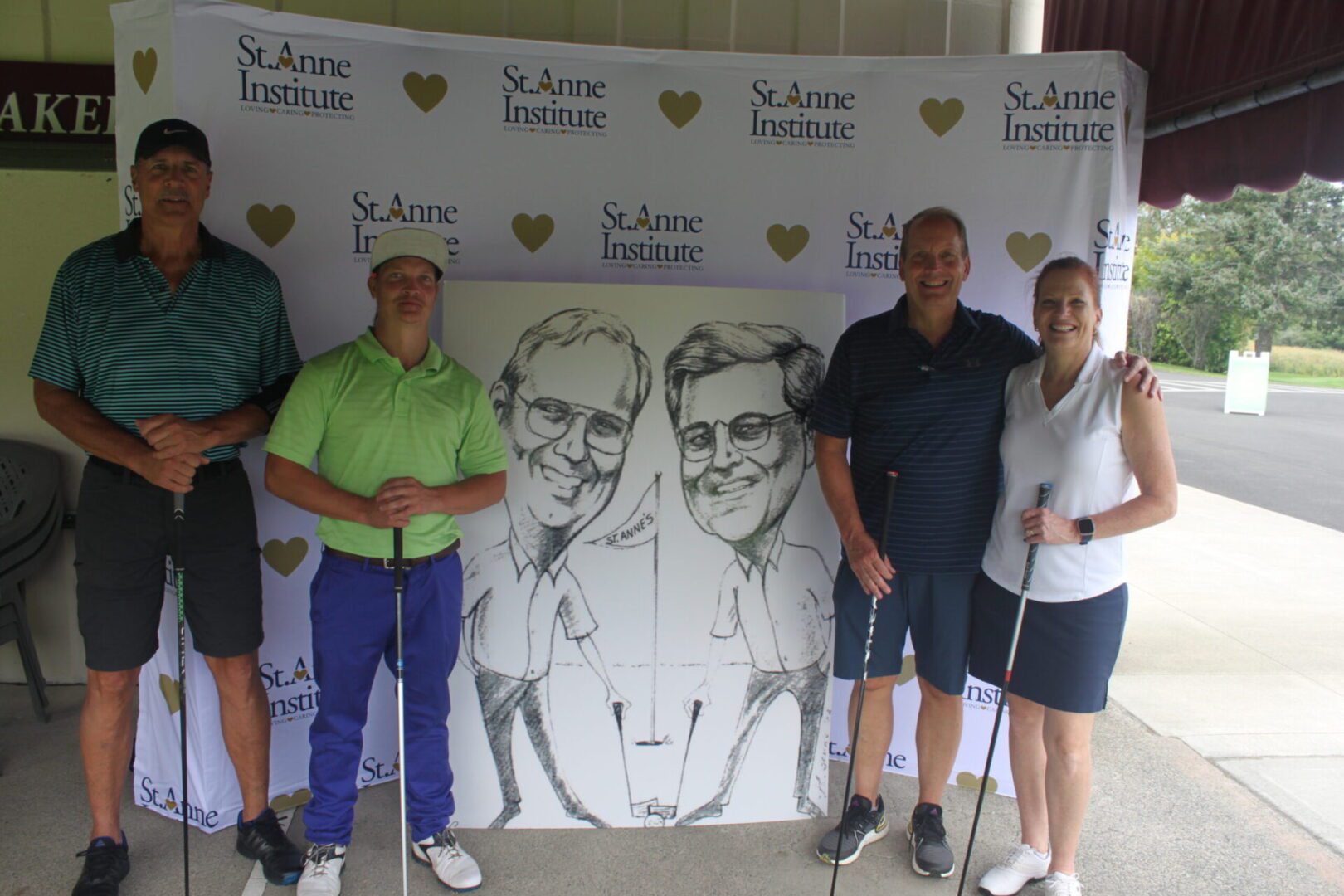 A group of people posing for a photo with a caricature.