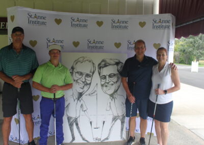 A group of people posing for a photo with a caricature.