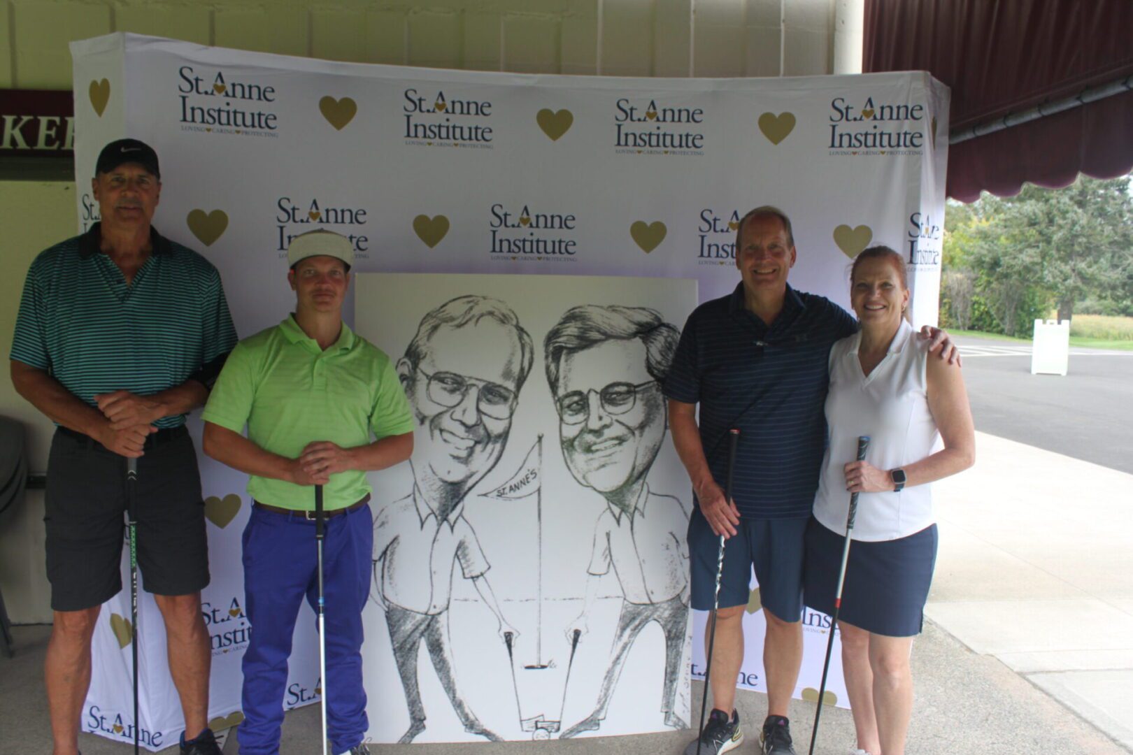A group of people posing for a photo with a caricature.