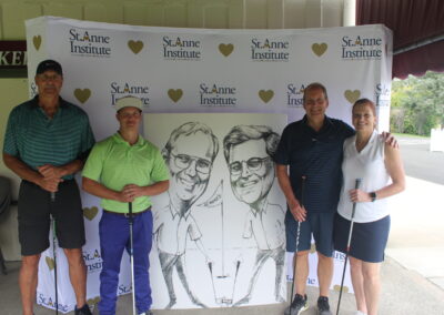 A group of people posing for a photo with a caricature.