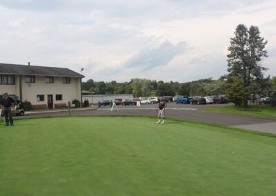 A man is playing golf on a green.