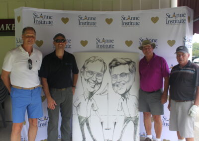 A group of men posing for a photo with a caricature.