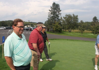 A group of men standing on a golf course.