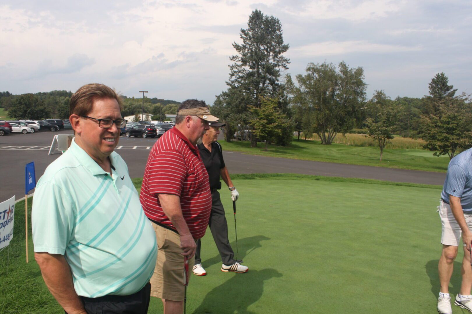 A group of men standing on a golf course.