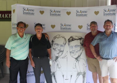 A group of men posing for a photo in front of a caricature.