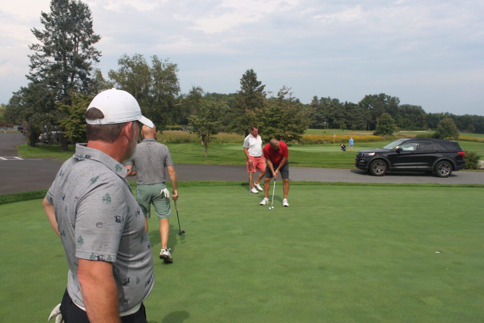 A group of people on a golf course.