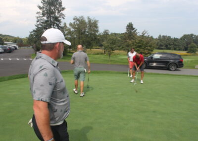 A group of people standing on a golf course.