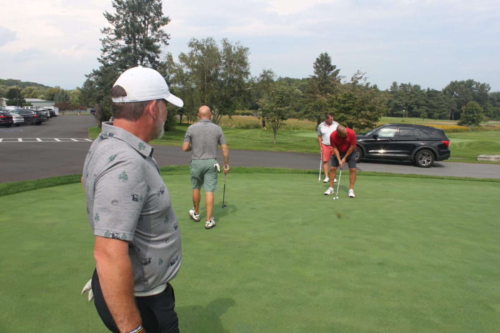 A group of people standing on a golf course.
