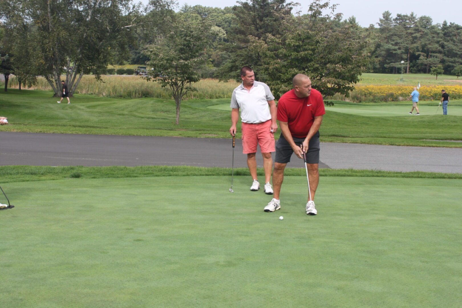 A group of people on a golf course.