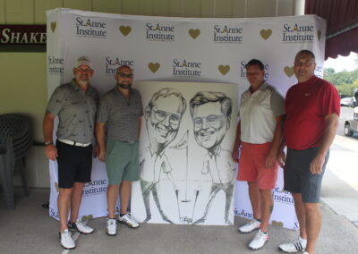 Four men posing for a photo with a caricature.