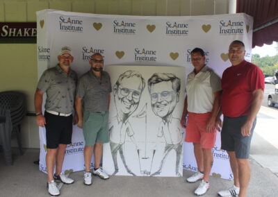 Four men posing for a photo with a caricature.