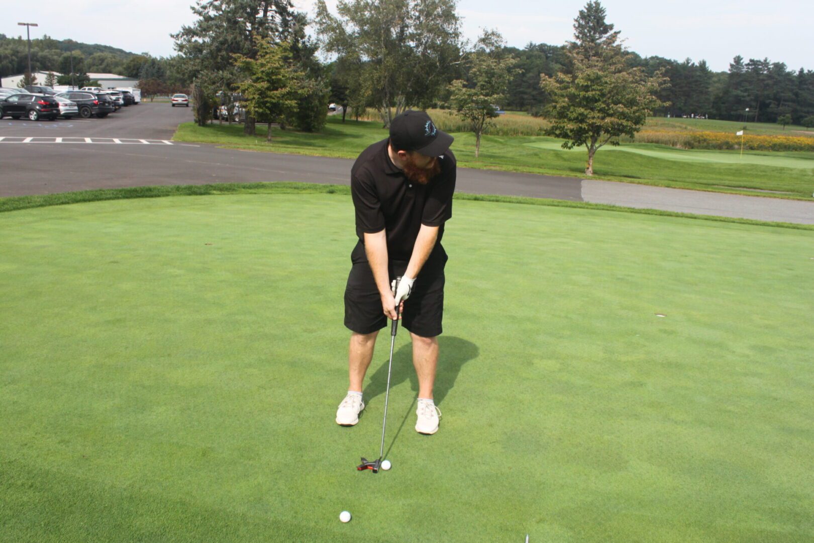 A man is putting a golf ball on a green.