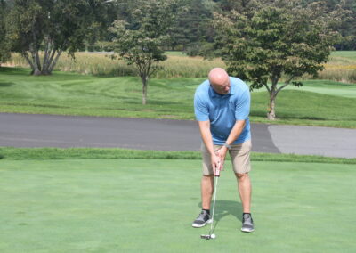 A man is putting a golf ball on a green.