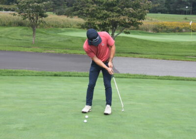 A man is putting a ball on a golf course.