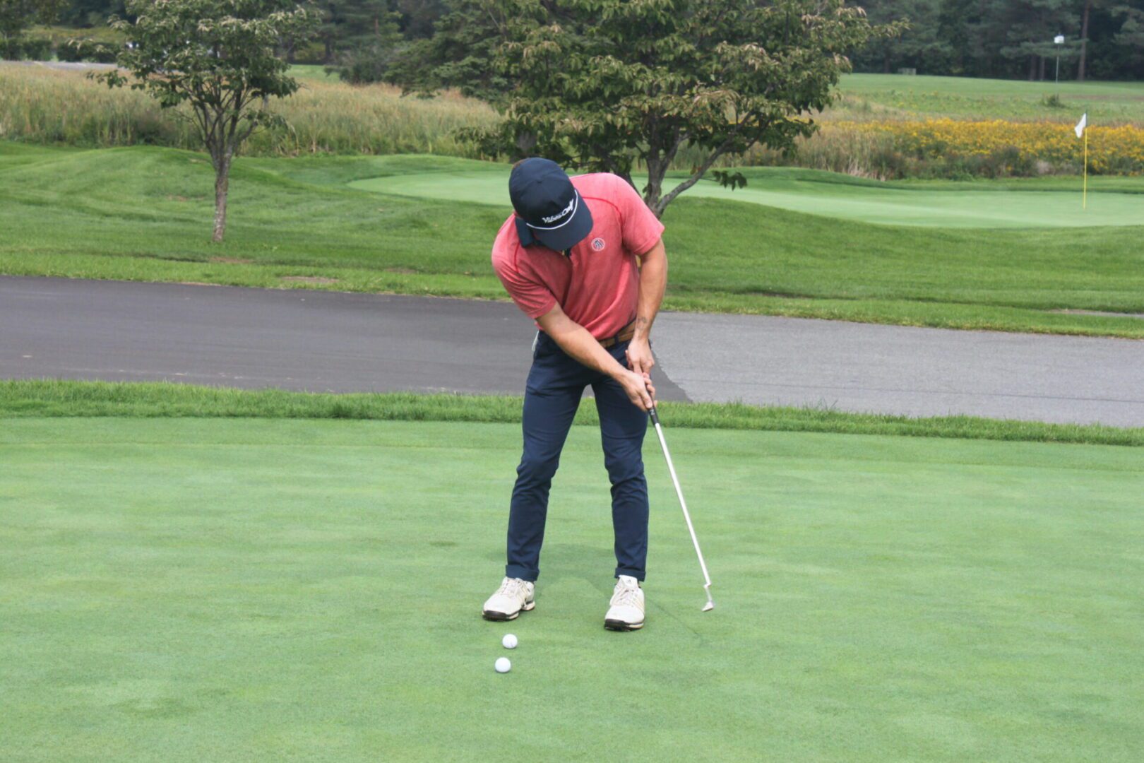 A man is putting a ball on a golf course.