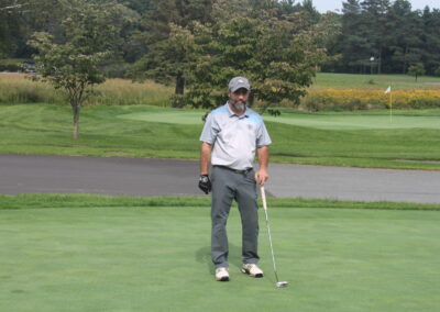 A man standing on a golf course with a golf club.