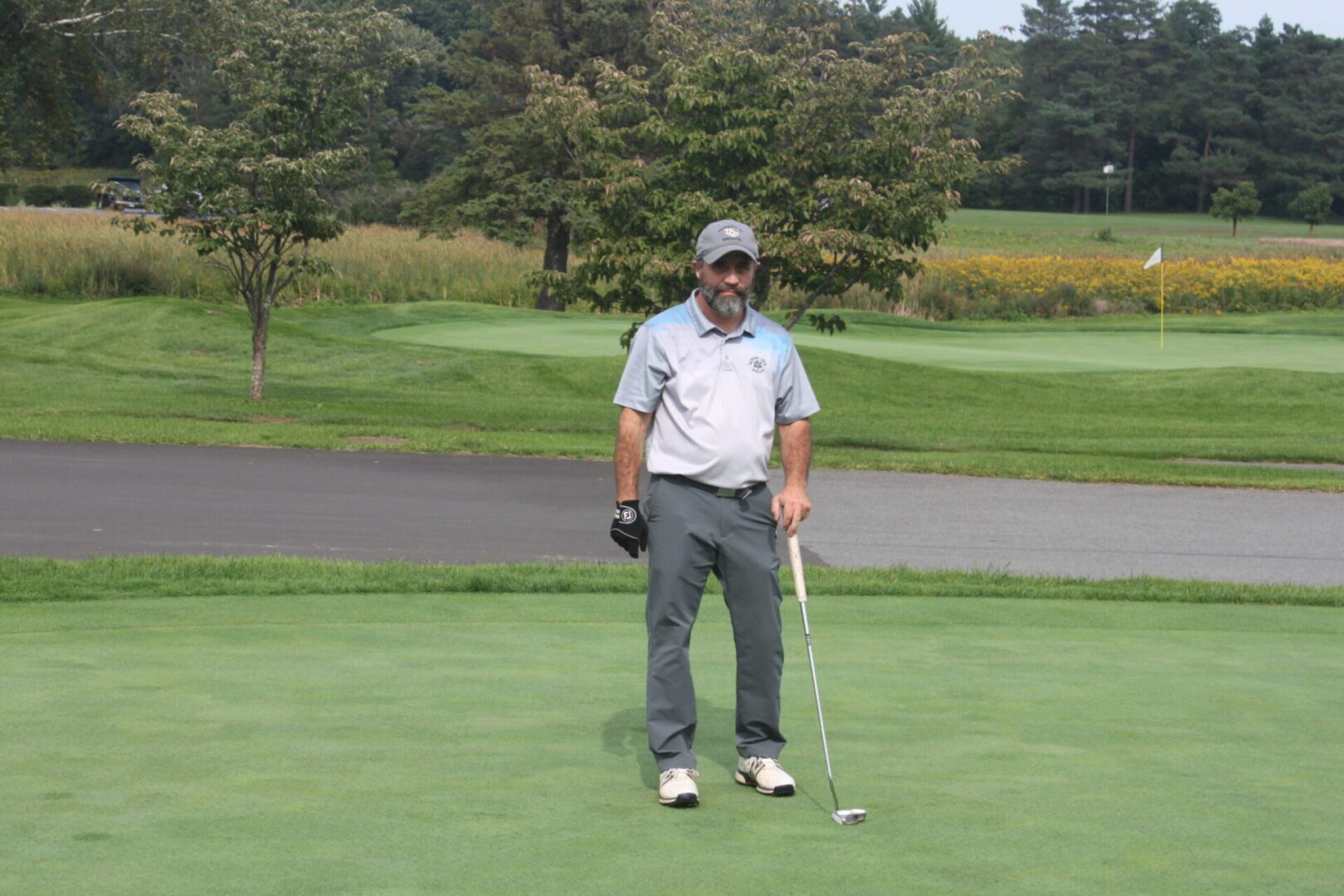 A man standing on a golf course with a golf club.